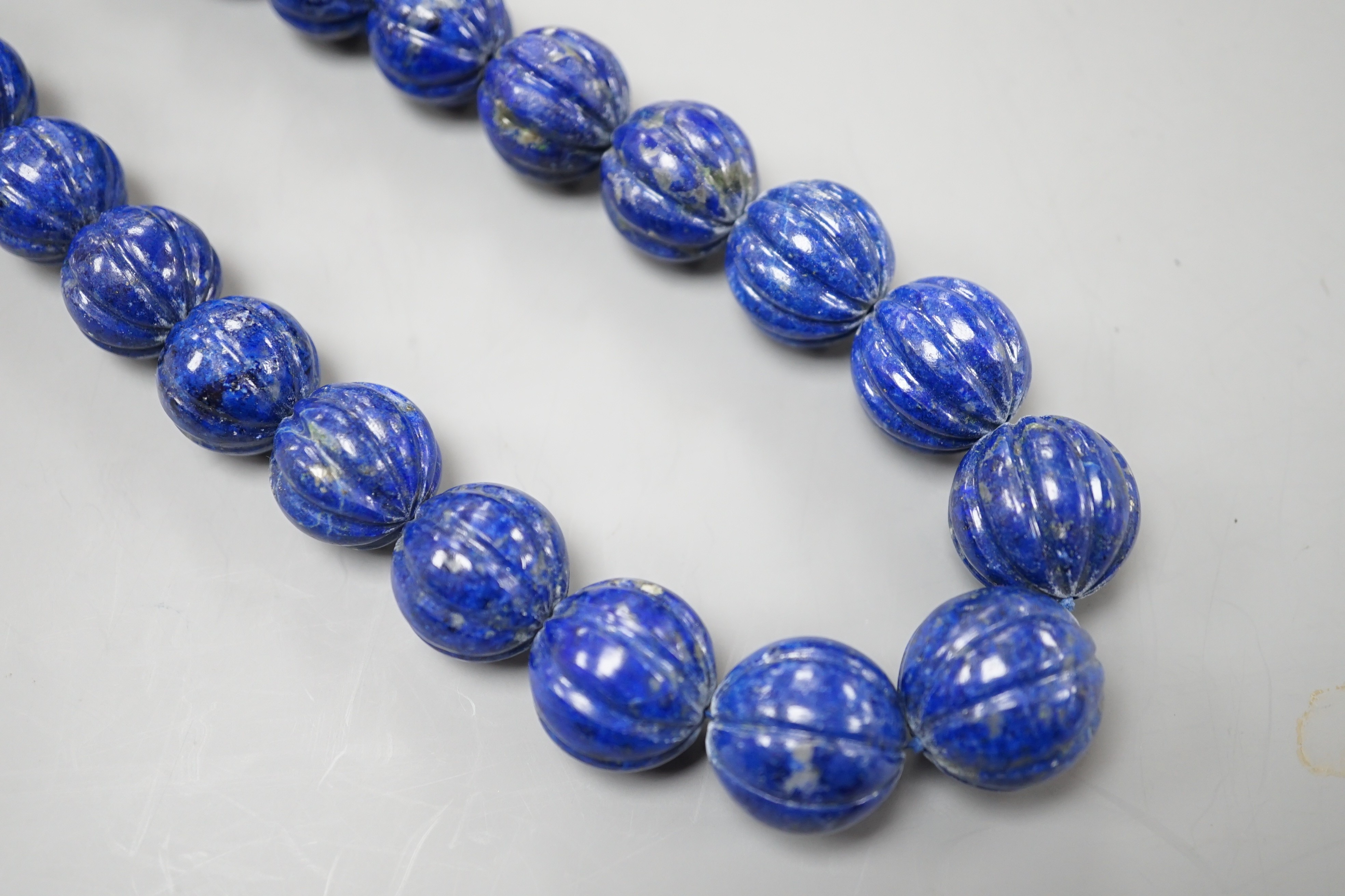 A single strand graduated fluted lapis lazuli bead necklace, 44cm